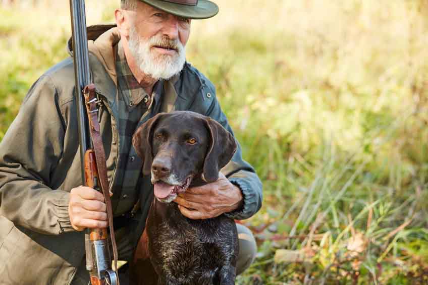 Un chasseur avec son fusil et son chien