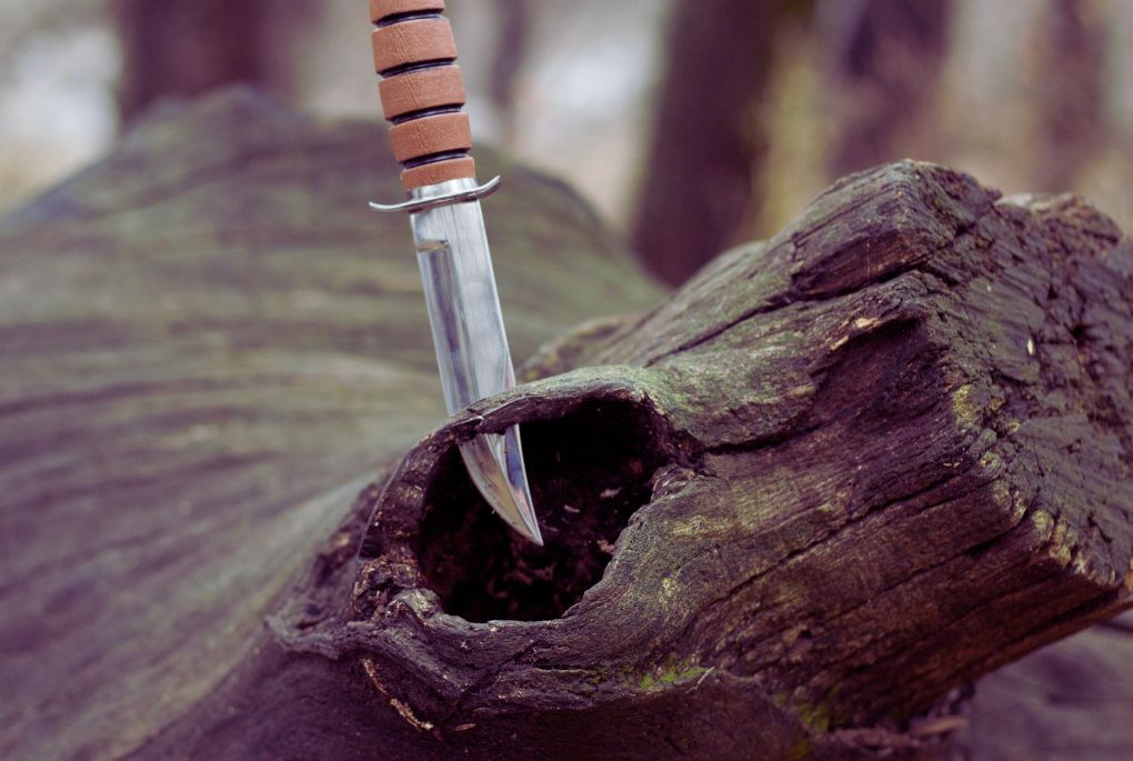 Un couteau de chasse planter dans un morceau de bois